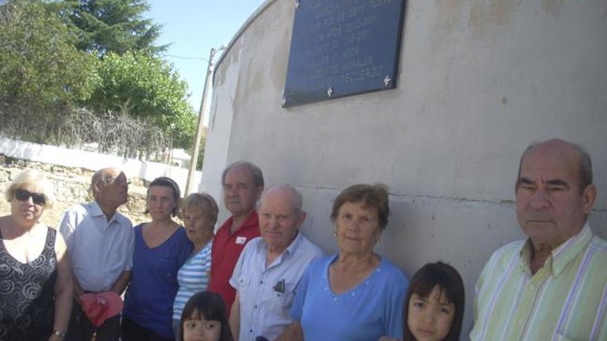 Los vecinos posan junto a la placa de la calle dedicada al sacerdote.