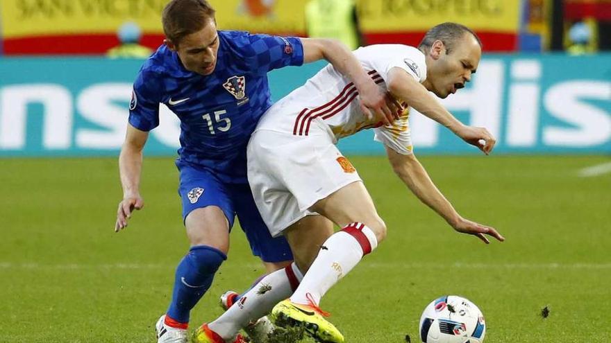 Iniesta, con el balón, cae ante la presión de Rog en el partido contra Croacia.