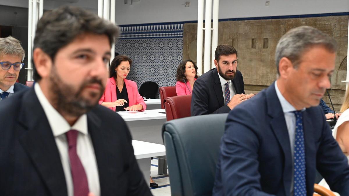 José Ángel Antelo, al fondo, mira a López Miras durante el debate de investidura (archivo).