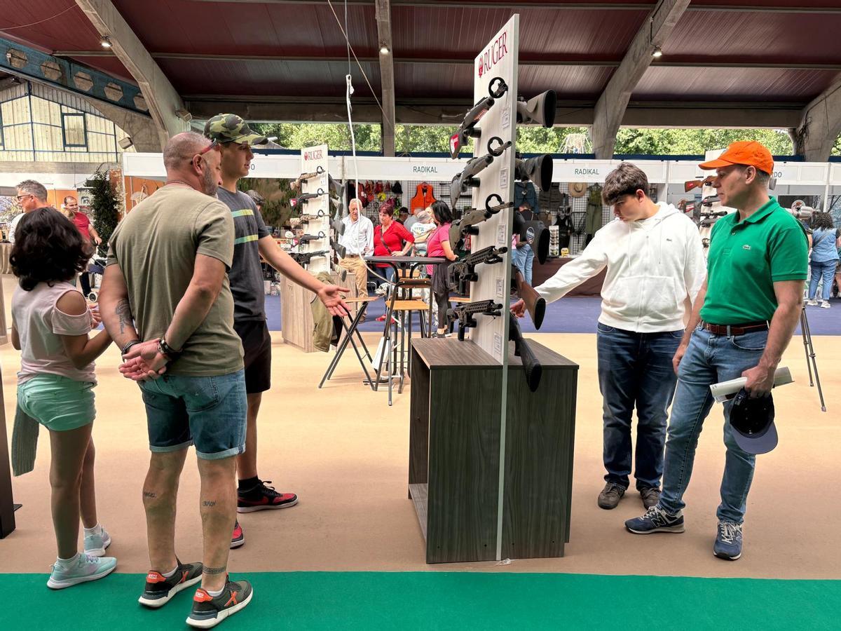 Visitantes en un expositor de armas.