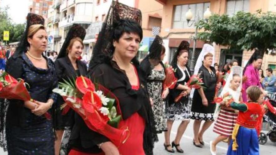 Las mujeres llevan flores a la Virgen