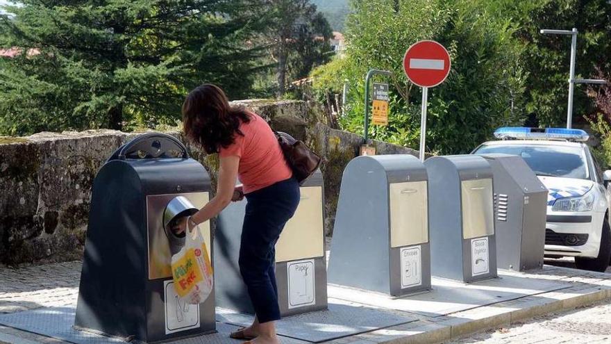 Una mujer realiza la separación de residuos en la isla de la plaza do Mosteiro. // Rafa Vázquez