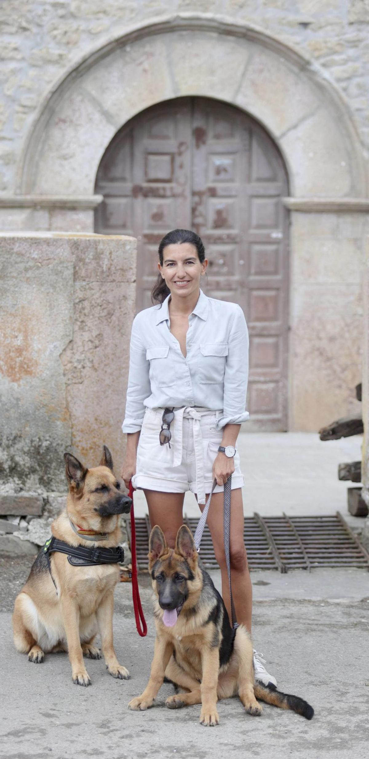 Rocío Monasterio posa para LA NUEVA ESPAÑA con sus perros: la veterana «Quinta» y «Six», de seis meses, delante de la iglesia de Viego. | Irma Collín