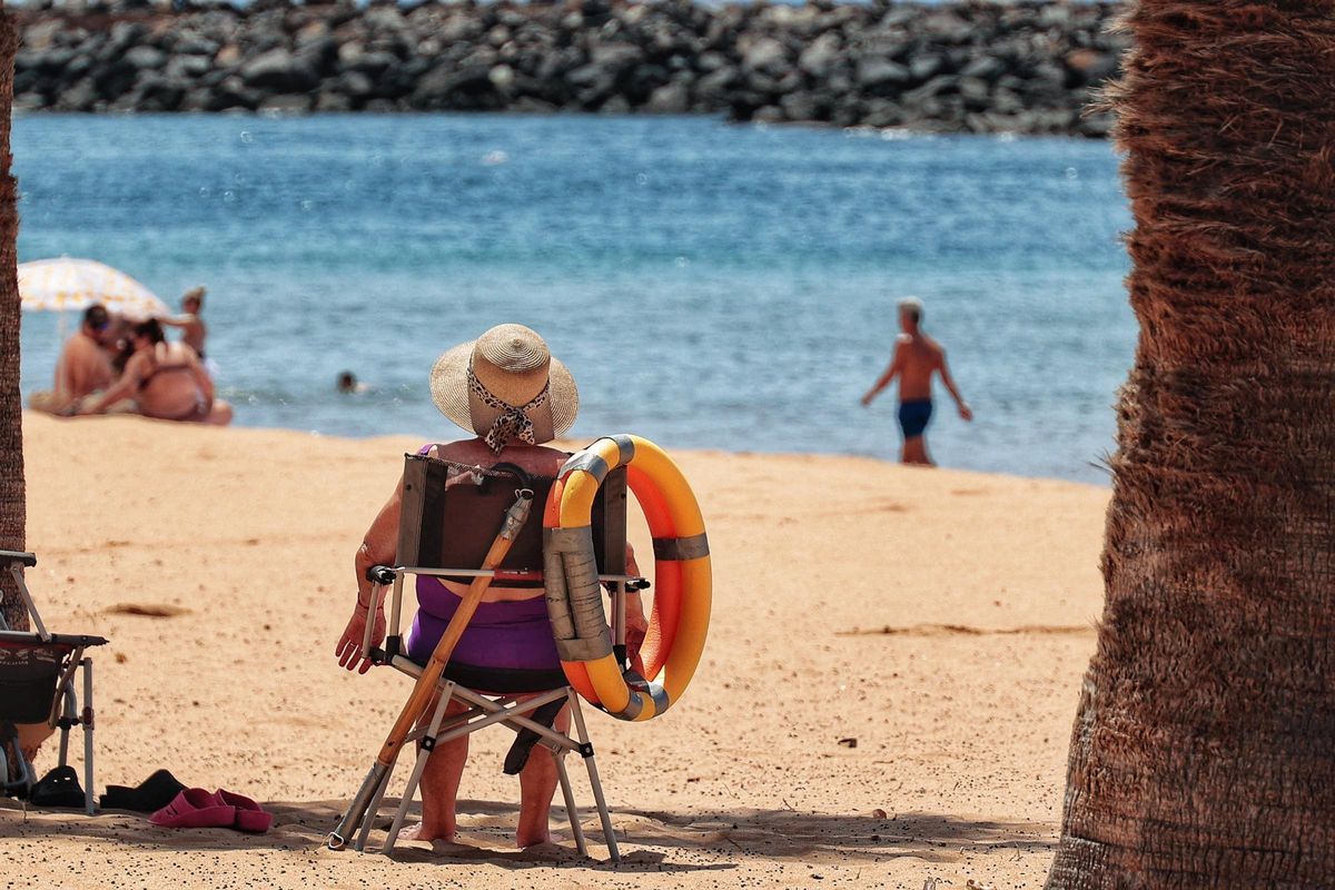 A woman takes shelter from the heat on Teresitas beach in Santa Cruz de Tenerife.