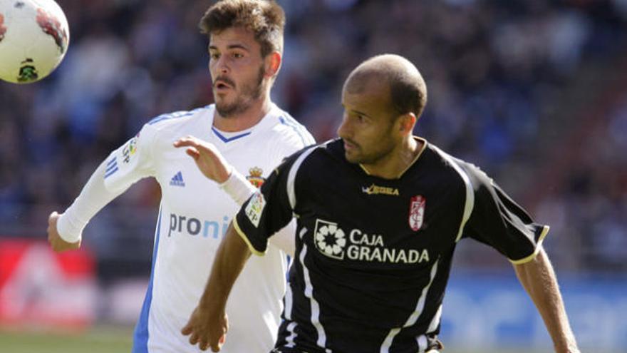 El centrocampista del Real Zaragoza Edu Oriol (i) pugna por el balón con el mediocampista del Granada CF Mikel Rico