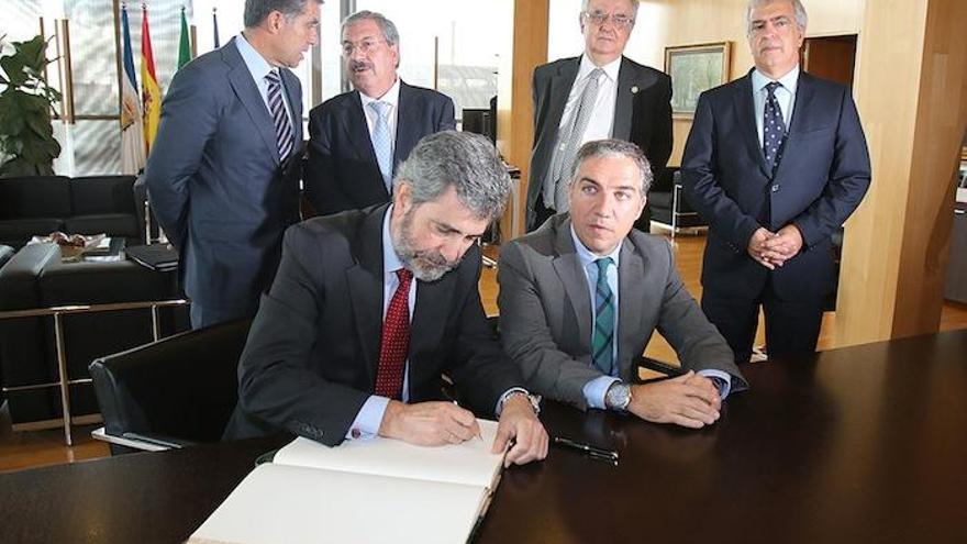 Carlos Lesmes firma en presencia de Elías Bendodo.