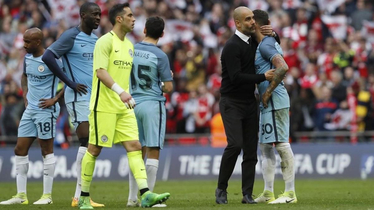 Guardiola consuela a sus jugadores al final del partido, este domingo en Wembley.