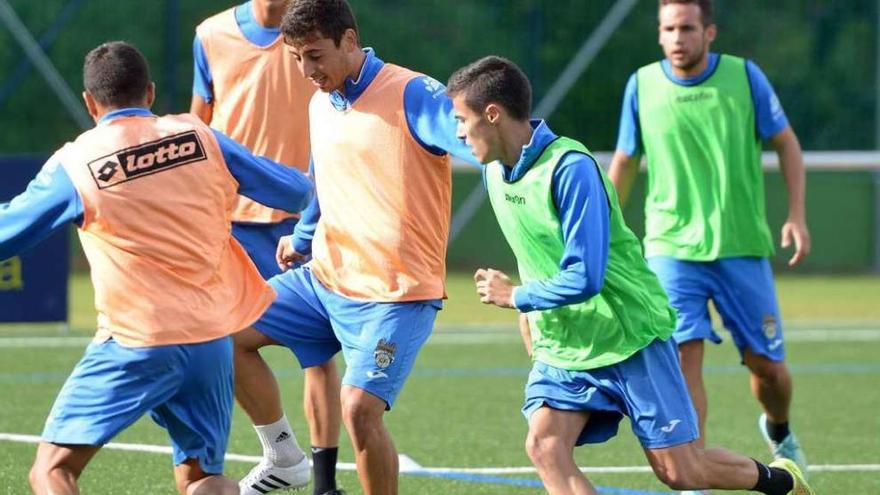 Kevin Presa trata controlar el balón ante la presión de varios de sus compañeros. // G. Santos