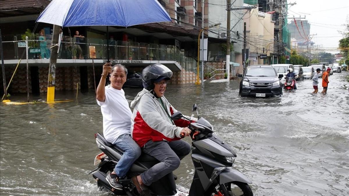 Un motorista maniobra en una calle inundada de Manila.