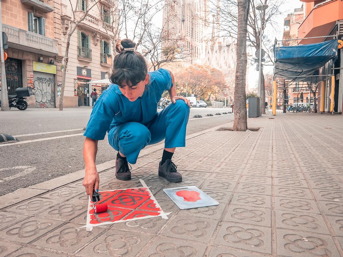 Emma France Raff, en la calle Mallorca, prepara la acera para estampar sus camisetas callejeras.