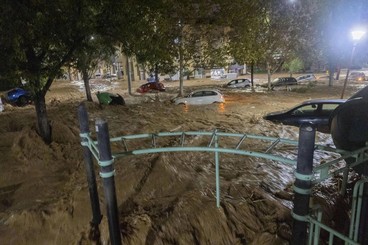 Coches arrastrados por el agua del barranco del Poyo desbordado en el Parque Villa Amparo de Paiporta, la noche del 29-O.