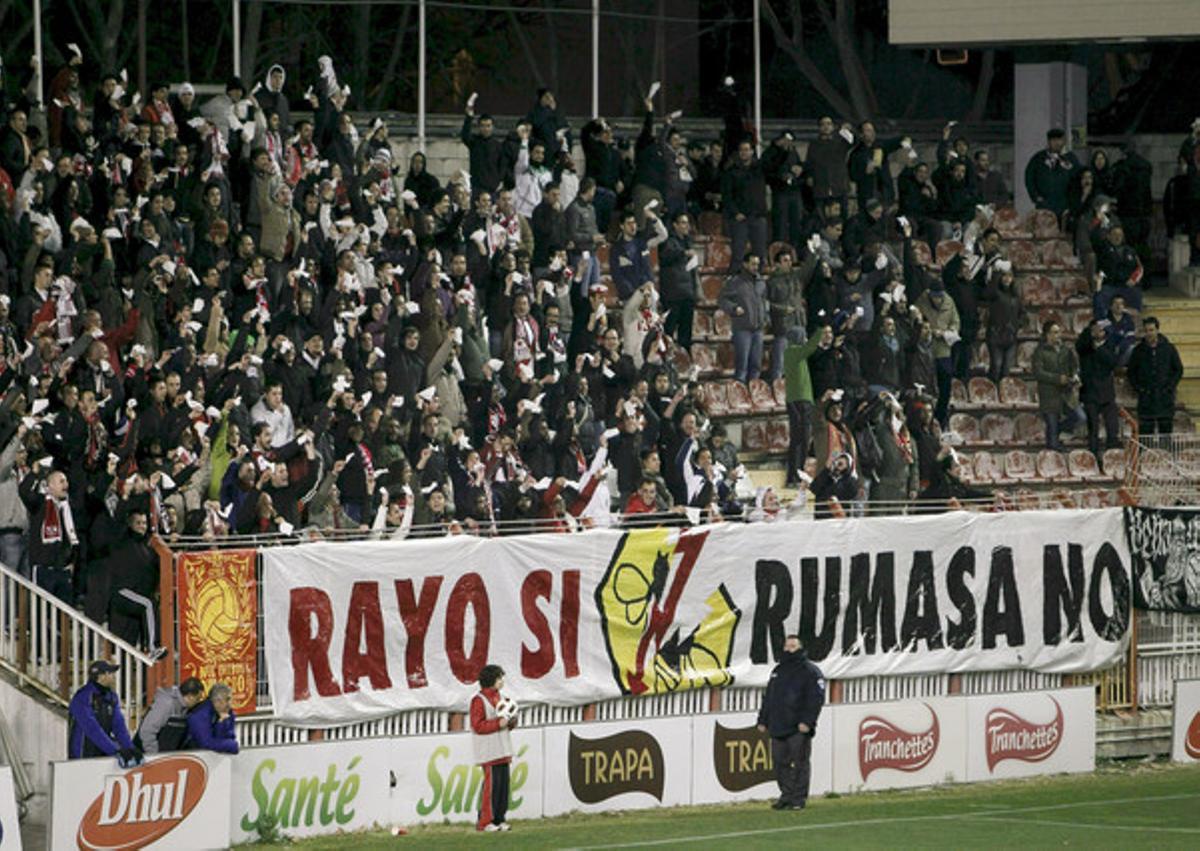 Unos aficionados muestran pañuelos junto a una pancarta alusiva al conglomerado empresarial Rumasa, de la familia Ruiz Mateos, propietaria del Rayo Vallecano en un partido contra el Alcorcón. 