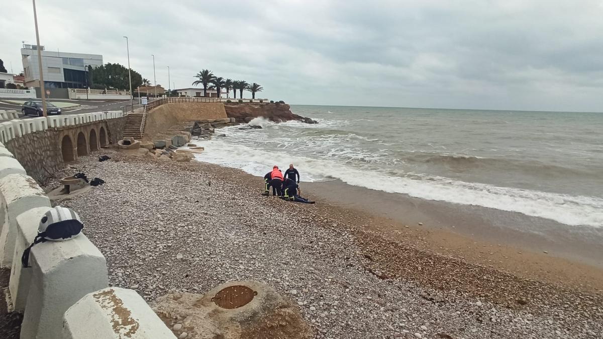 Efectivos del Consorcio Provincial de Bomberos extraen el cuerpo del asesinado del mar.