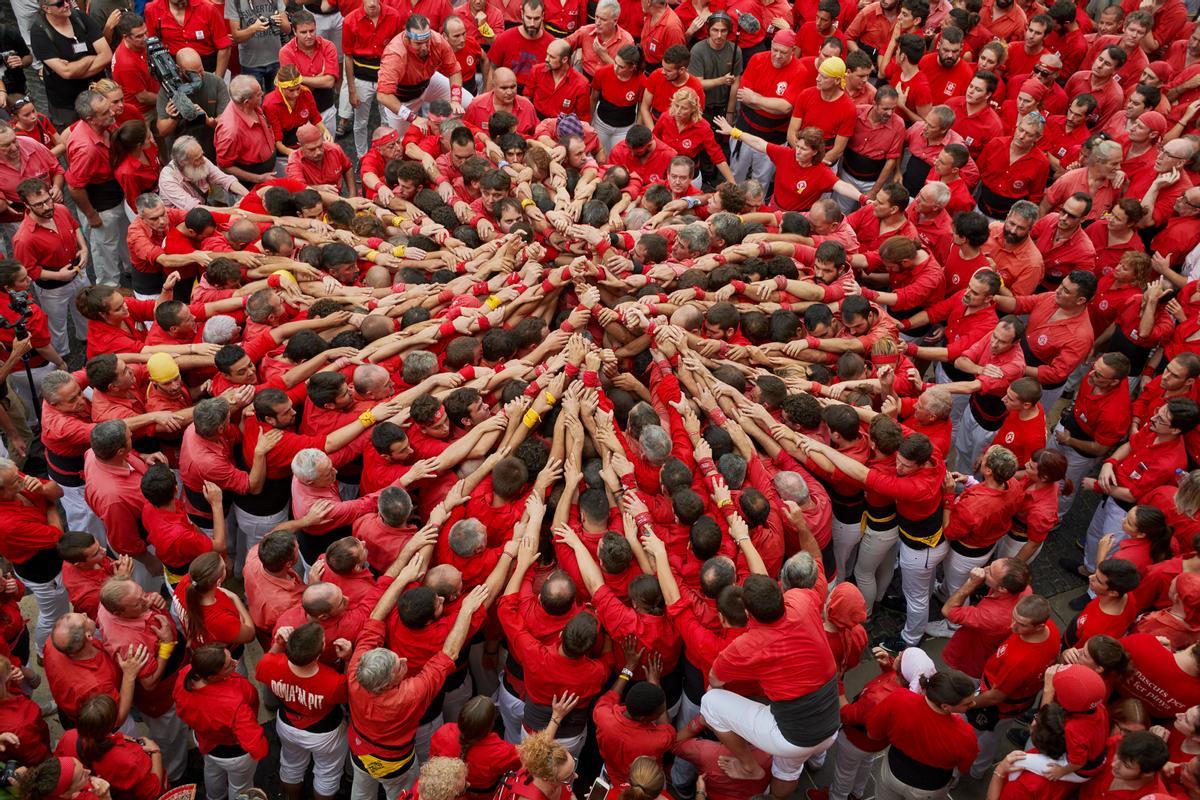 ’Castellers’ se preparan para levantar una torre humana en Barcelona. 2018.