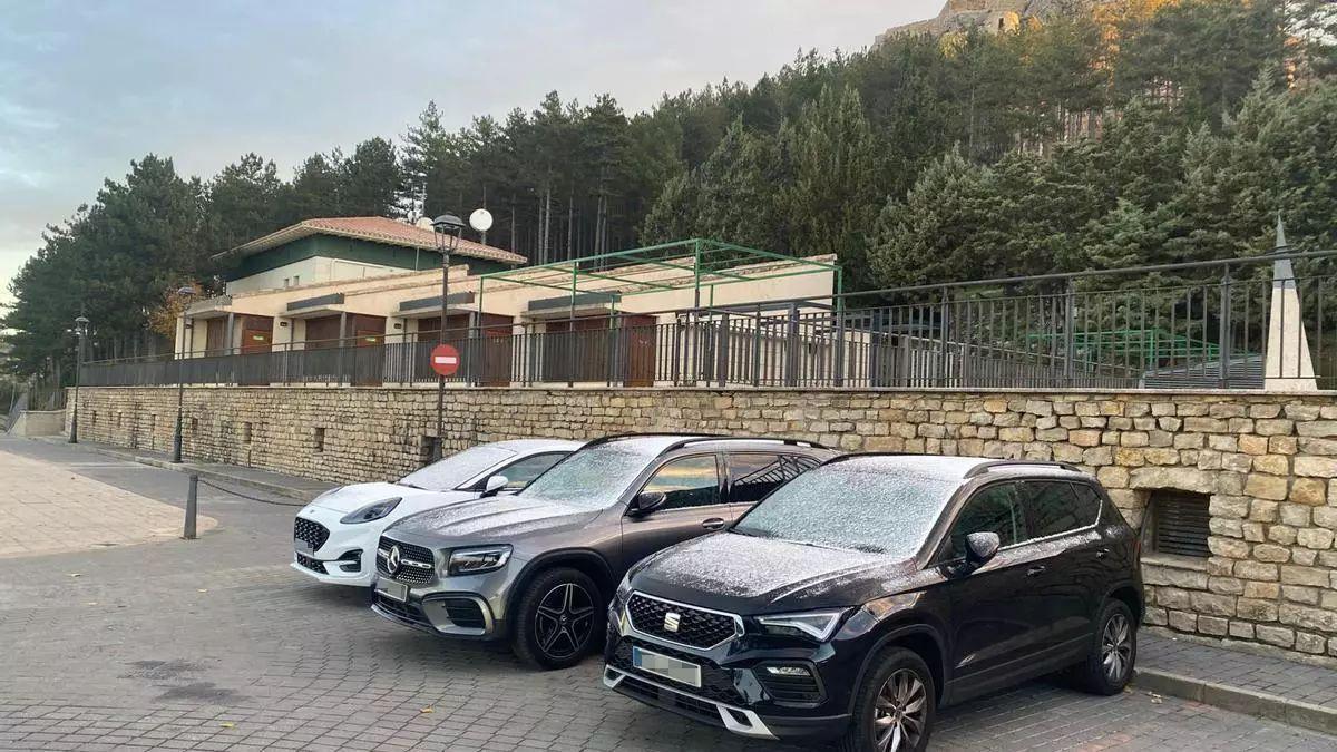 Imagen de archivo de coches aparcados en la escuela infantil de Morella, con una fina capa de nieve.
