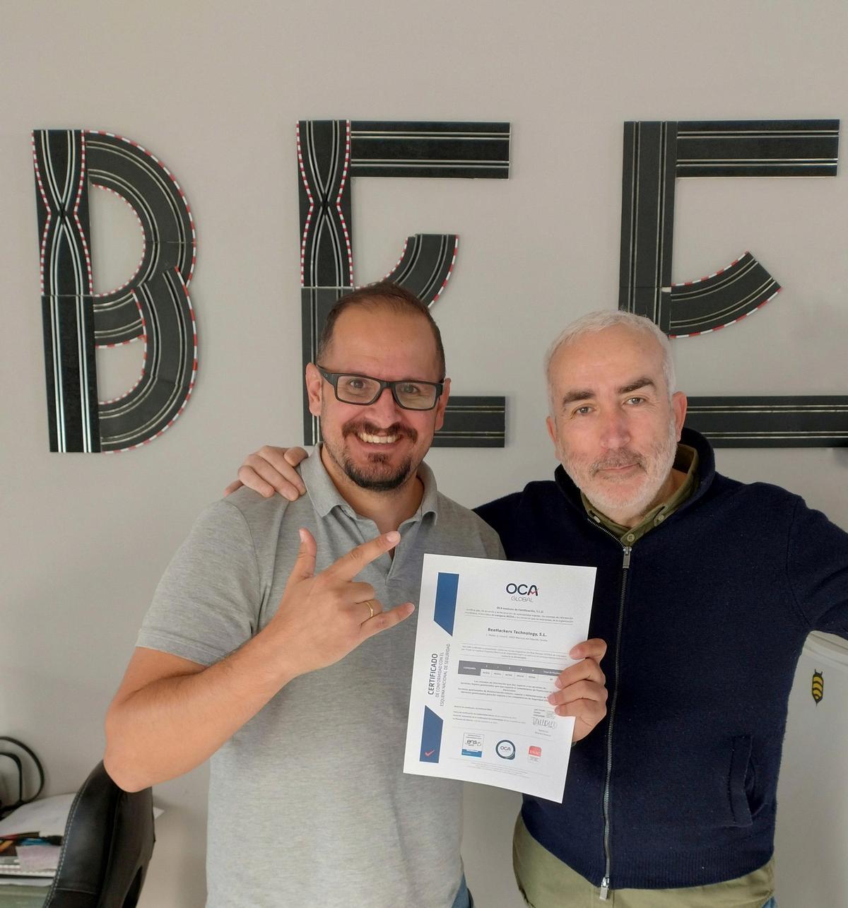 Ramón Salado y Daniel Alcántara, mostrando la certificación de Esquema Nacional de Seguridad obtenida por BeeHackers.