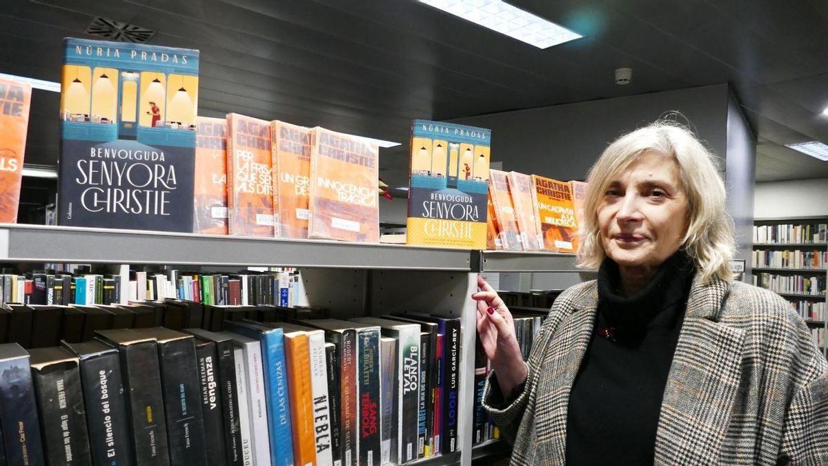 Núria Pradas amb el seu llibre i tot de volums d'antigues edicions d'Agatha Christie, a la biblioteca de Figueres.