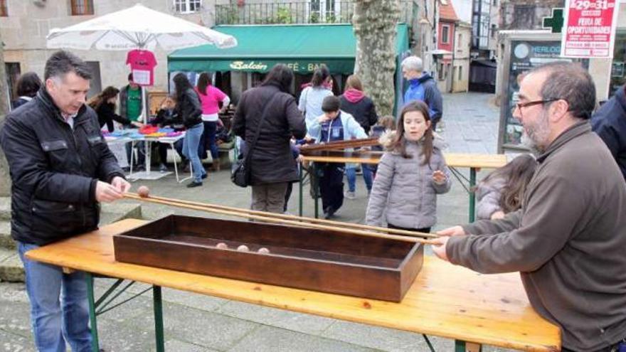 El concejal de Juventud y Cándido Mascato (a la derecha) practican juegos tradicionales.  // Muñiz