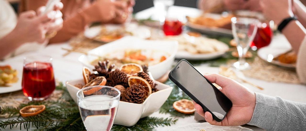 Una familia en la mesa de Navidad, todos con móviles