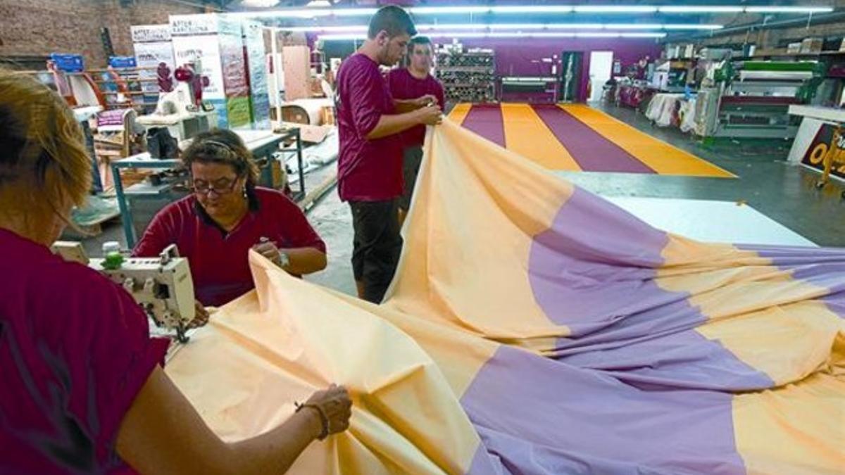 La confección 8 Los trabajadores de la empresa Marc Martí, en pleno proceso de fabricación de la 'senyera' que ayer presidió la manifestación.