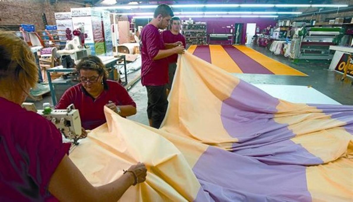 La confecció 8 Els treballadors de l’empresa Marc Martí, en ple procés de fabricació de la senyera que ahir va presidir la manifestació. La confecció 8 Els treballadors de l’empresa Marc Martí, en ple procés de fabricació de la senyera que ahir va presidir la manifestació.