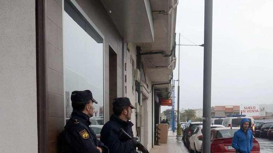 Agentes armados a las puertas del edificio de Cambados. // Noé Parga