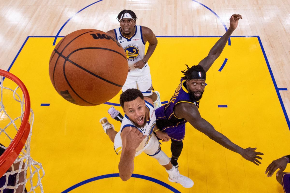 El jugador de los Golden State Warriors, Stephen Curry, dispara la pelota de baloncesto contra el de Los Angeles Lakers, Patrick Beverley,.