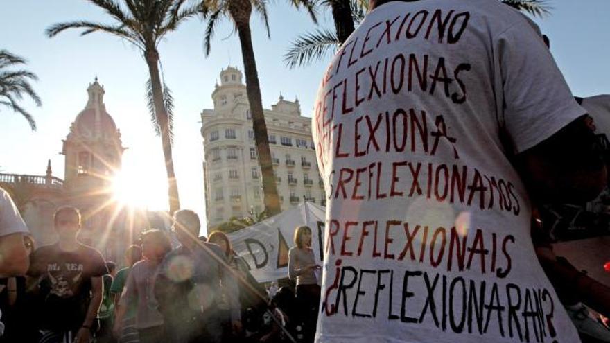 Un hombre muestra una camiseta con diversas preguntas sobre la jornada de reflexión, esta tarde en la Plaza del Ayuntamiento de Valencia