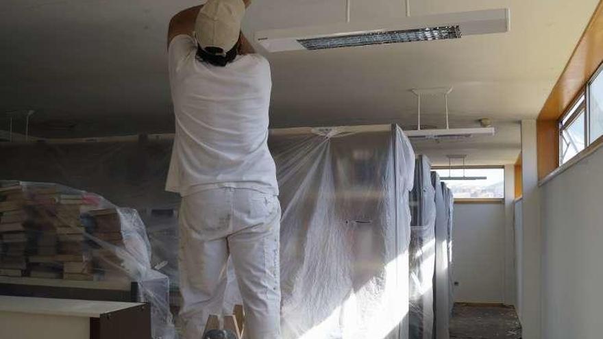 Un operario repara el techo de la biblioteca de Redondela. // FdV