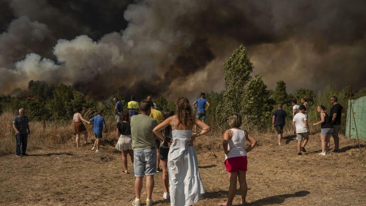 Un grupo de personas observa la virulencia del fuego en la zona de A Rasela. | // BRAIS LORENZO