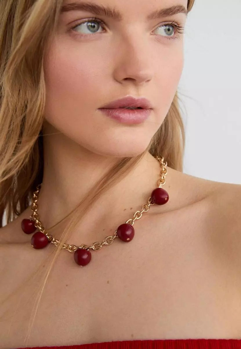 8 Collares de Stradivarius que te transportarán a tu infancia y serán tu accesorio estrella del verano 14 Moncloa Collar dorado de cerezas de Stradivarius por 9,99 euros