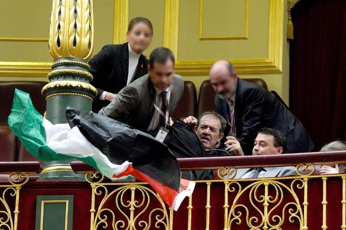 Un activista es reducido en el Congreso de los Diputados al protestar por la guerra en Gaza durante un pleno del Congreso.