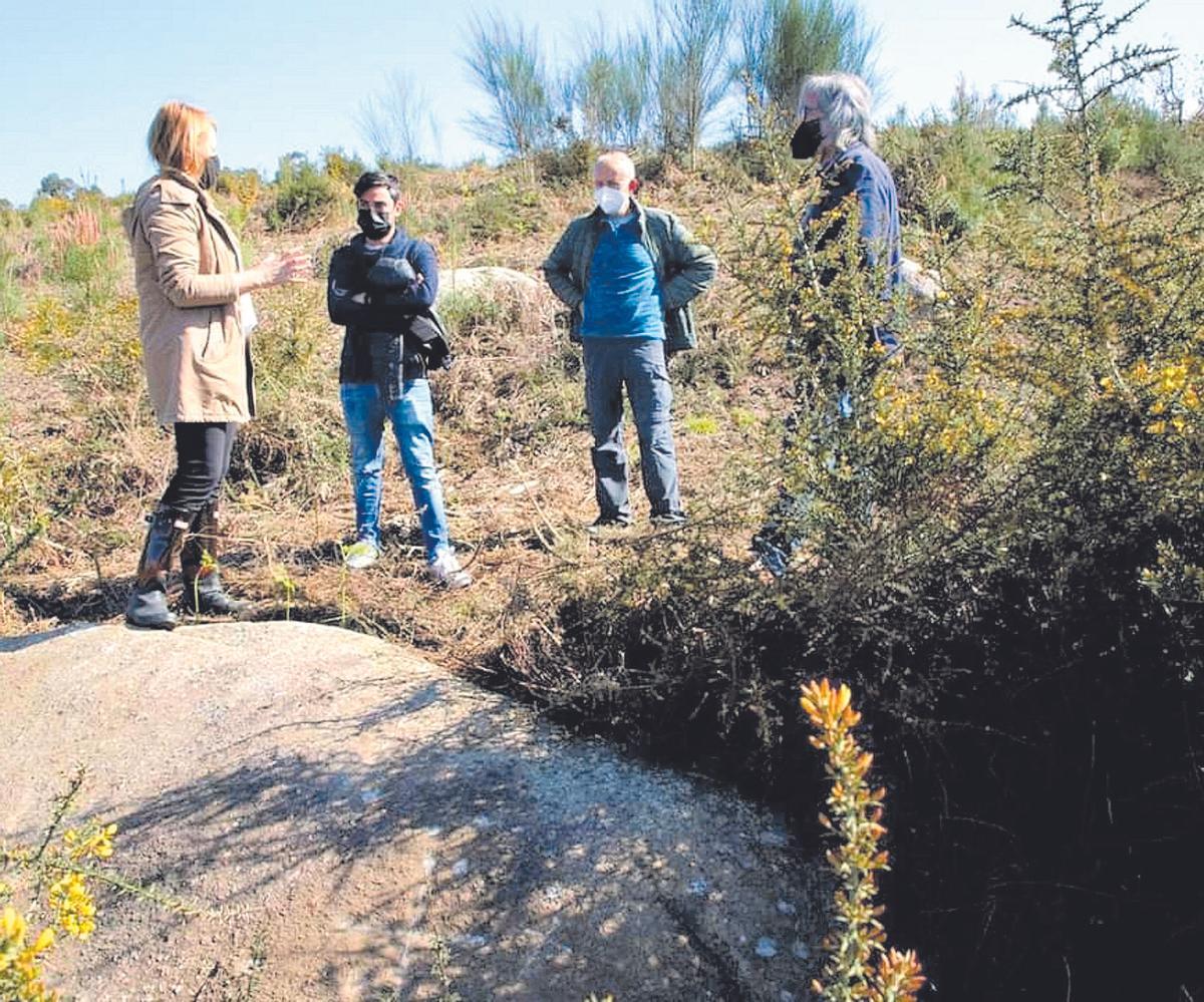 La alcaldesa y el edil de Patrimonio, junto al presidente de los comuneros sobre la roca grabada. // D.P.