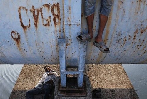 Un hombre duerme bajo una tubería en la India.