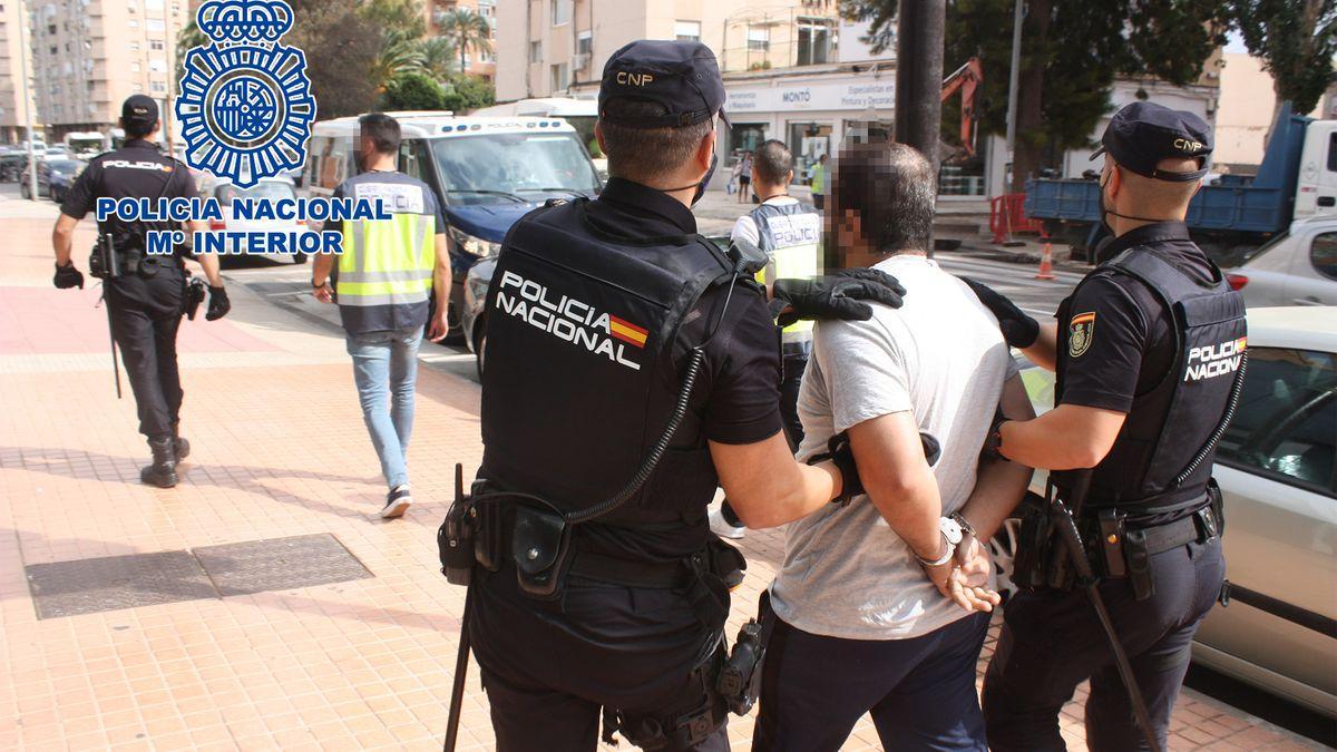 La Policía, llevando al detenido.