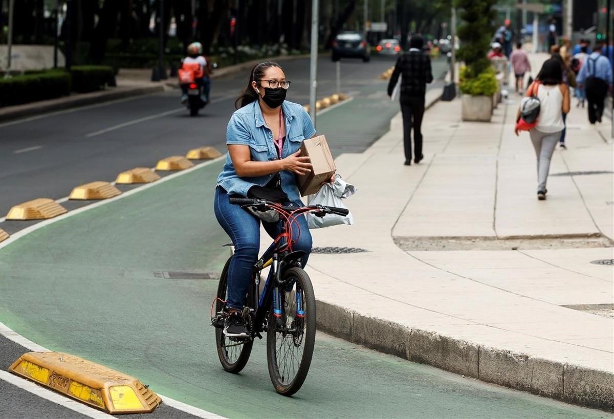 Una mujer circula en su bicicleta en Ciudad de México, duramente golpeada por la pandemia.