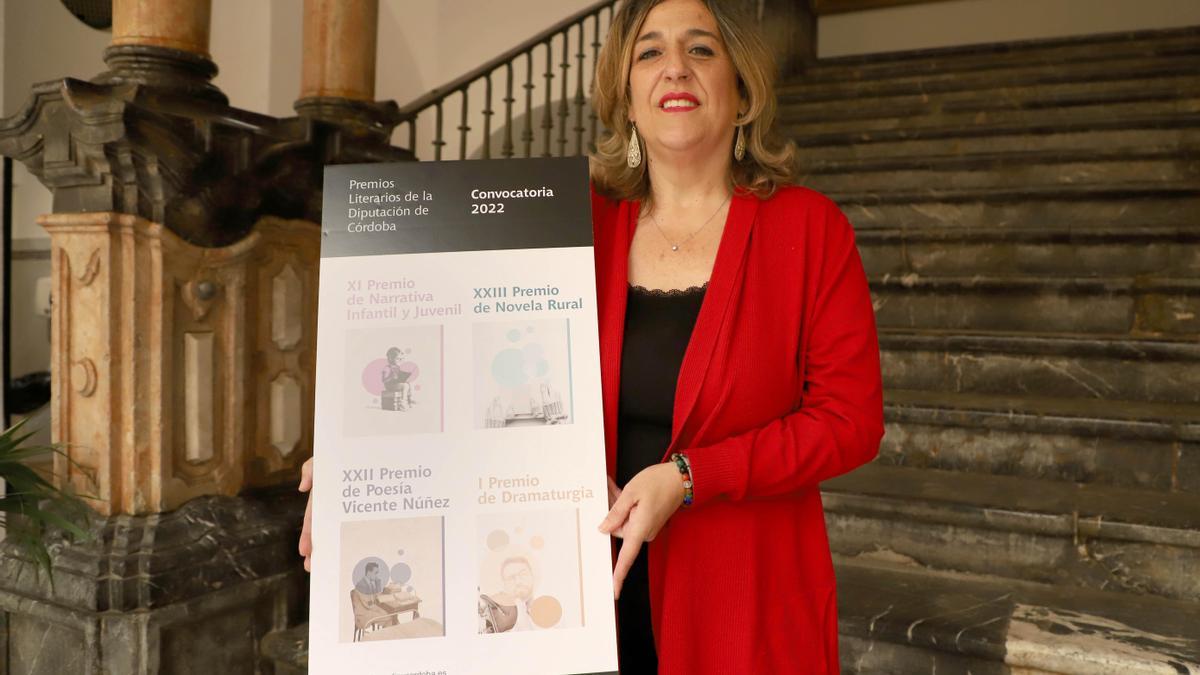 Salud Navajas muestra el cartel de la convocatoria de premios.