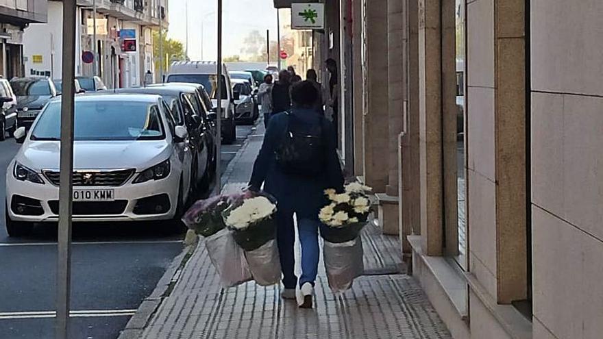 Una ciudadana porta varios ramos de flores, ayer.  | // A.CELA