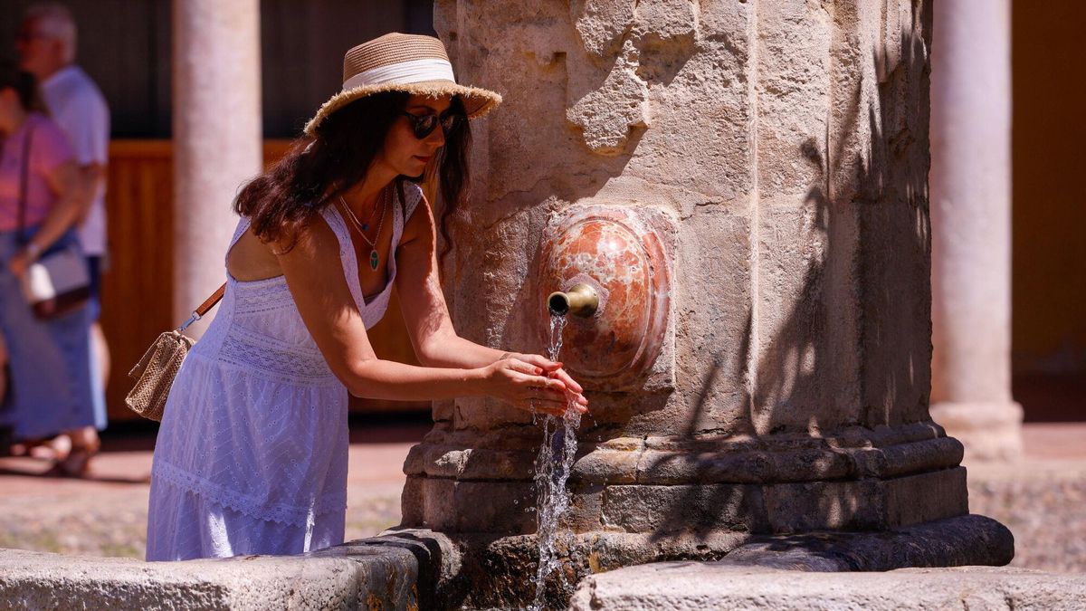 Una mujer se refresca en una fuente del Patio de los Naranjos de la Mezquita-Catedral de Córdoba, ayer.