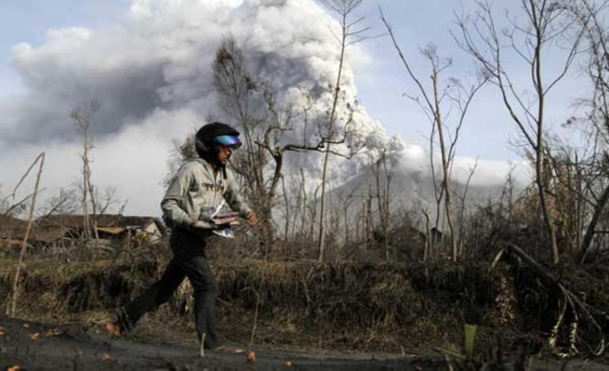 Un home corre amb les seves pertinences al poble de Kalitengah, a l’illa de Java (Indonèsia). El volcà Merapi ha començat a mostrar signes de letargia, encara que les autoritats no han abaixat el nivell d’alerta per la intensa activitat sísmica.