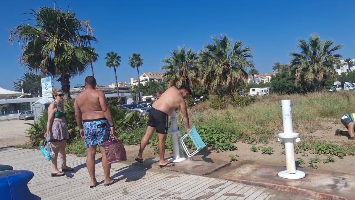 Un bañista repasa las sillas de playa en el lavapiés de la playa del Raset