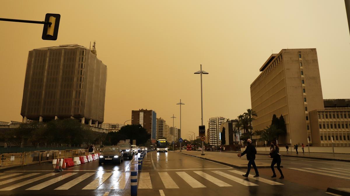 La calima deja el cielo de Málaga de color naranja y los coches llenos de polvo