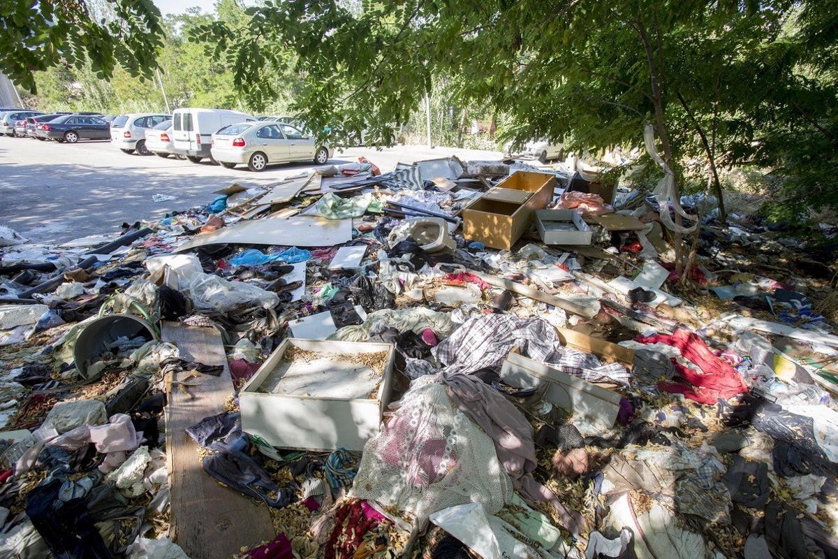 Acumulacion de basura y suciedad entre la maleza que crece al final del párking provisional ubicado en el ultimo tramo de la avenida Albert Bastardas debido al abandono de la masia de Can Rigalt y sus alrededores.