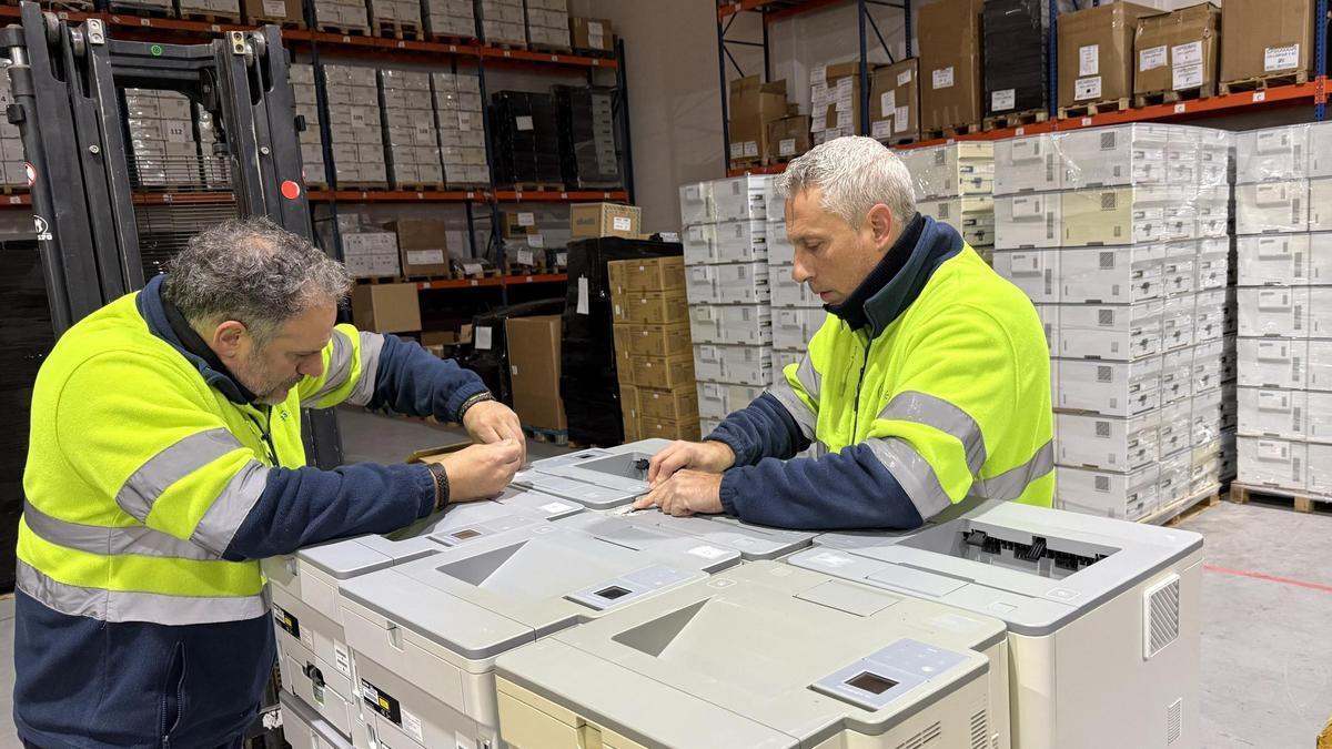 Dos empleados de la tienda de tecnología reacondicionada Digalco en el almacén de la empresa.