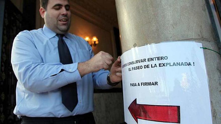 Un conserje de la Casa Carbonell, frente al edificio donde se han colocado los carteles animando a los vecinos a firmar