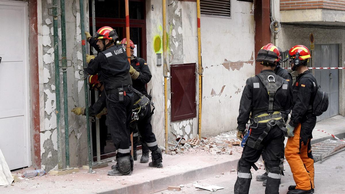 Unos bomberos apuntalan un edificio durante el terremoto de Lorca