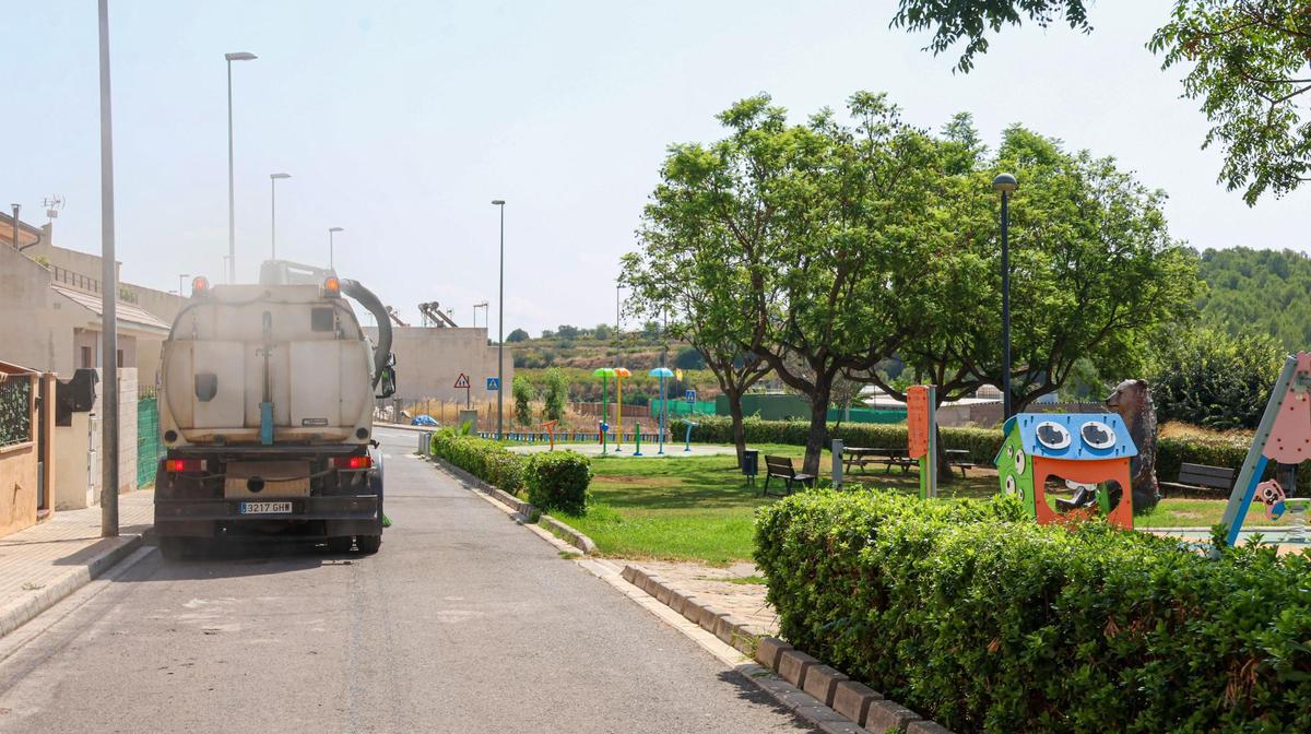 Un camión intensifica las labores de limpieza junto a un parque.