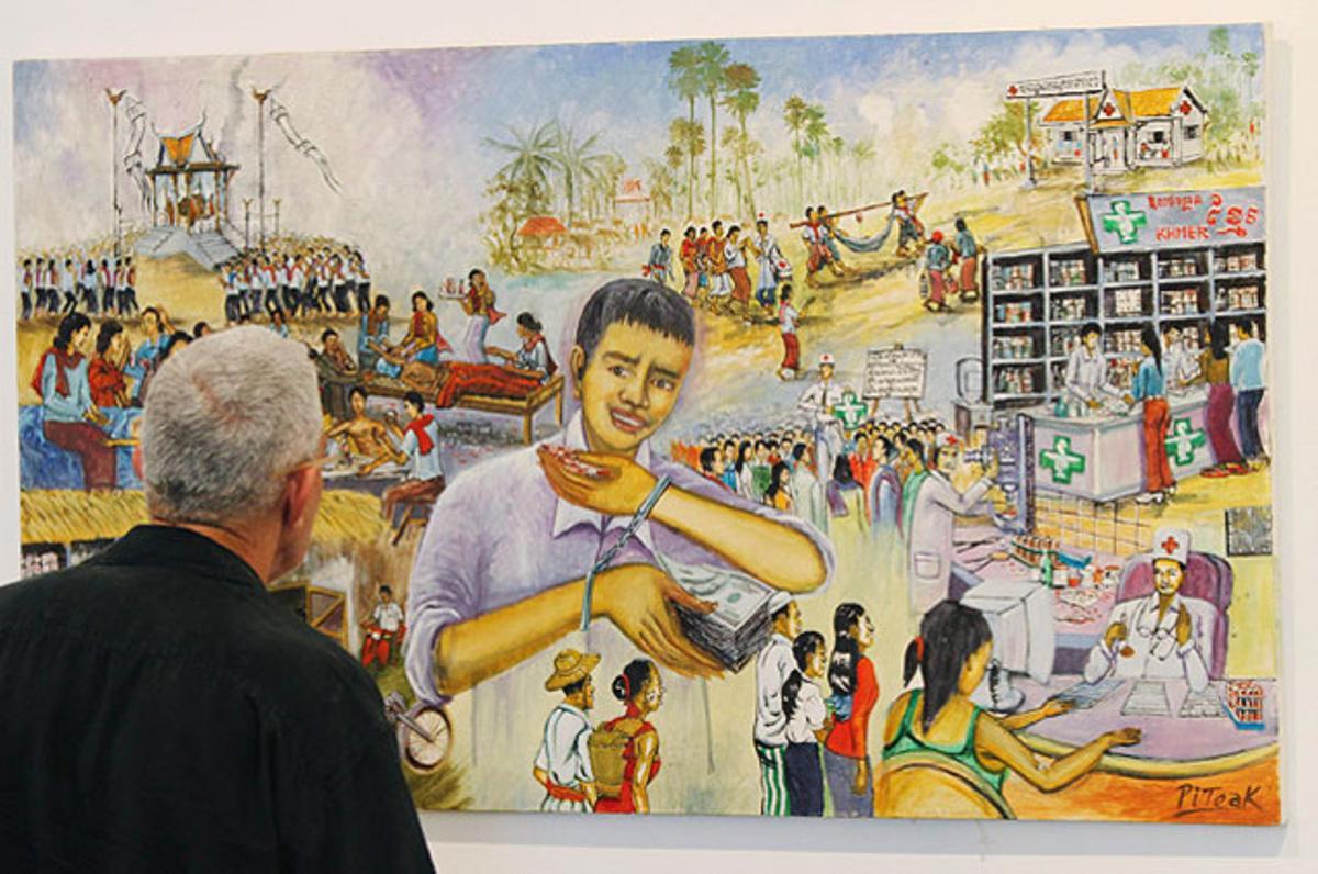 Un visitant contempla el quadro ’A dake drug seller is a killer’ de Sokuntak Piteak. Aquesta obra forma part de l’exposició ’Pharmacide’, organitzada pel Centre Cultural Alemany i Cambodja, que intenta augmentar el coneixement sobre els perills de salut associats amb medicaments falsos, a Phnom Penh.