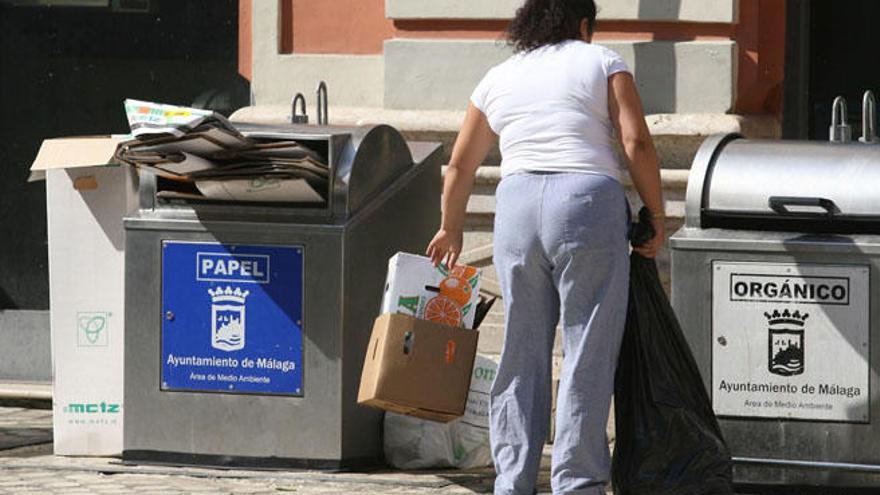 Una mujer tira la basura en un contenedor soterrado del Centro.