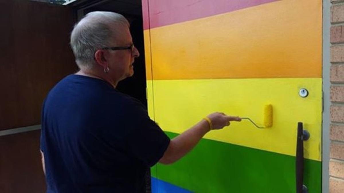 Un voluntario de la comunidad de Wedgewood pinta las puertas de la iglesia.